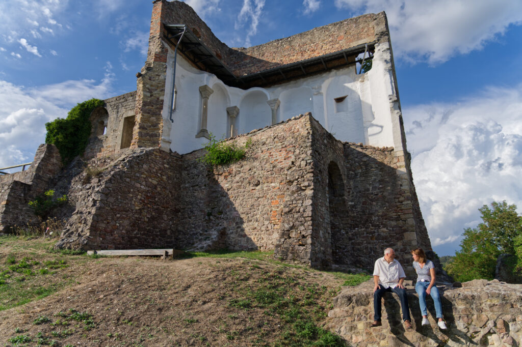 Ruine mit zwei Personen im Gespräch im Vordergrund.